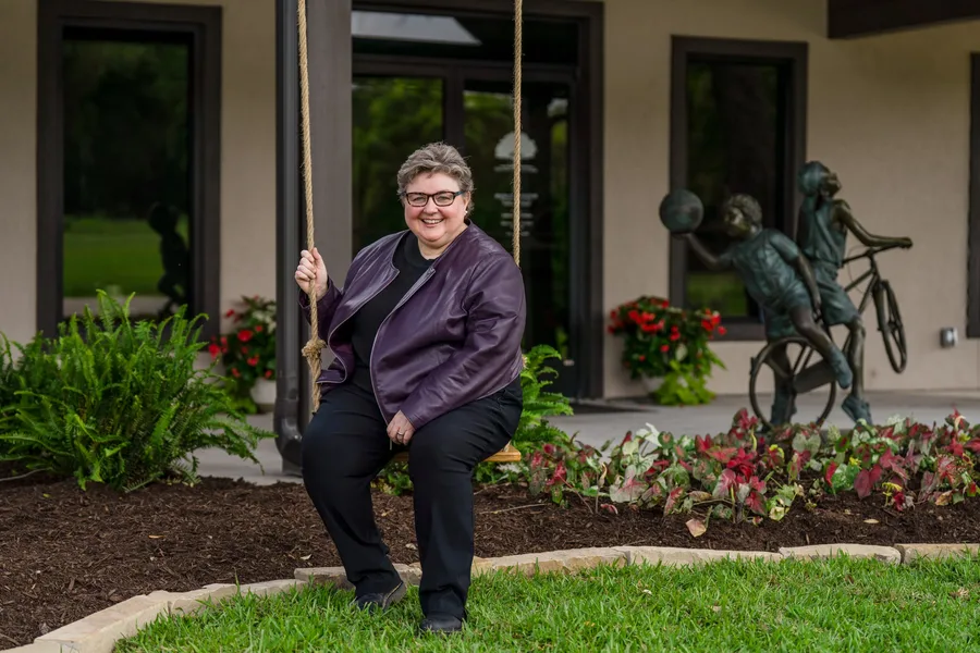 An attorney seated on the garden swing outside the Pearland office